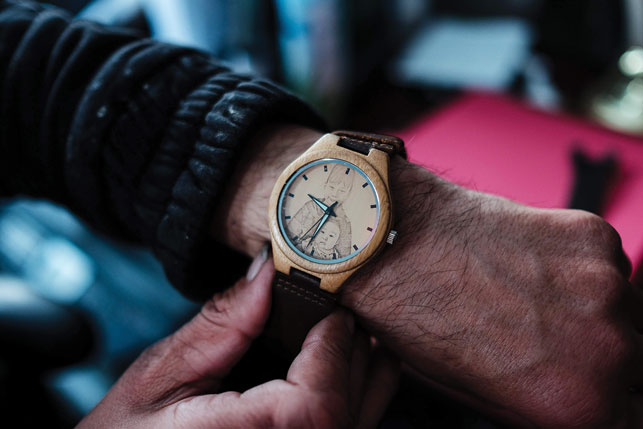 Kikoak shows off a watch with a portrait of his two grandchildren. He doesn’t want to disappoint them, though he says he knows he is hurting them.