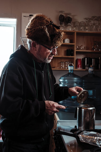 Hans Maurer makes breakfast and morning coffee. The retired chef’s “cabin gourmet” meals are legendary. Photo by Weronika Murray