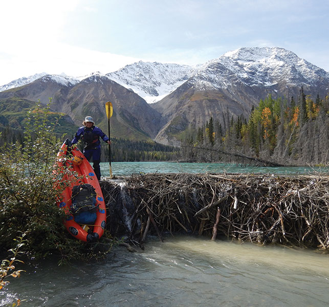THERESA LANDMAN WITH A 16-LB PACKRAFT ON RANGE CREEK. Photo courtesy of Bob Daffe.