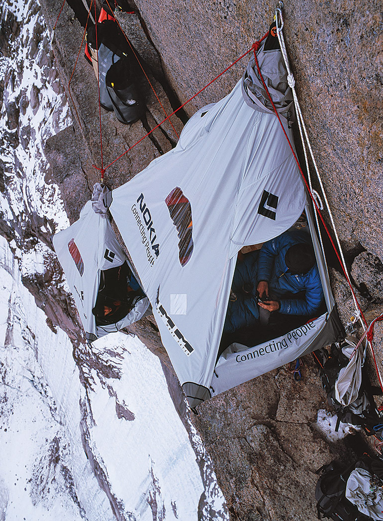 A portaledge (portable ledge) camp at 4,900 feet, almost halfway up Asgard’s north face. Campers sleeping in these hanging, canvas-covered cots are strapped in with a harness attached to the rock wall.