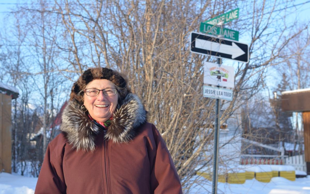 Lois Little in front of the Lois Lane sign