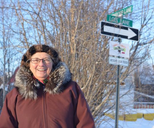 Lois Little in front of the Lois Lane sign