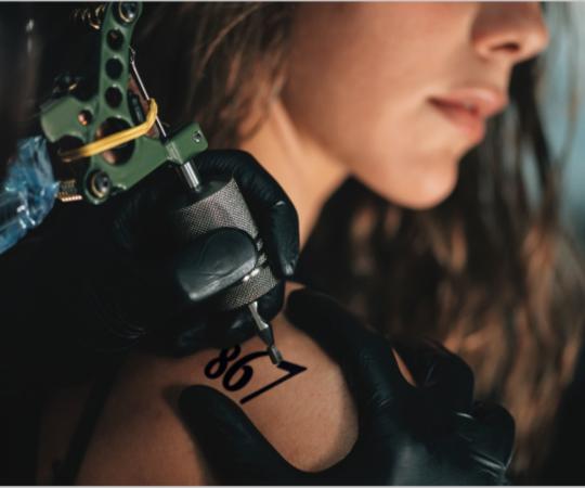 A woman gets "867" tattooed on her shoulder